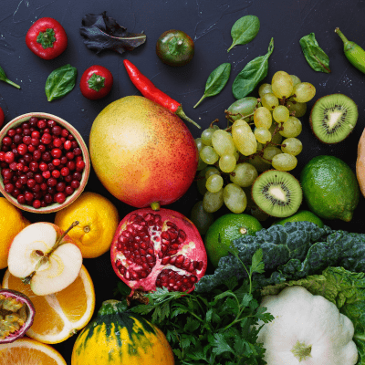 A colourful selection of fresh fruit and vegetables on a dark background